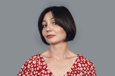 Portrait of young woman against white background