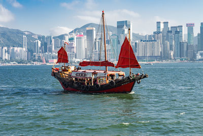 View of sailboat in sea against buildings