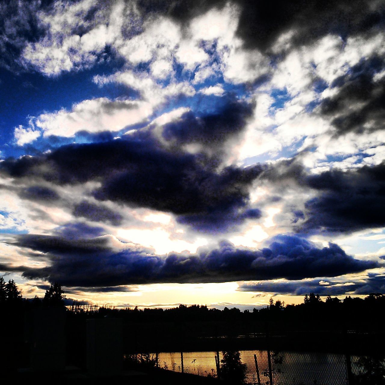 sunset, sky, silhouette, tranquil scene, scenics, tranquility, water, beauty in nature, cloud - sky, lake, nature, cloud, cloudy, reflection, idyllic, tree, dramatic sky, river, calm, outdoors