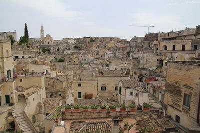 High angle view of old buildings in town against sky