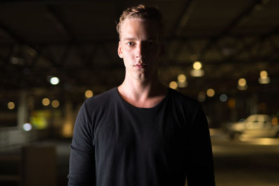 Portrait of young man standing at night