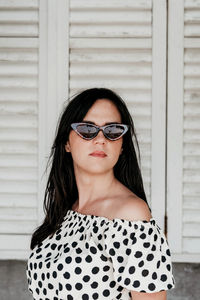 Portrait of attractive young woman wearing summer polka dot dress. sunglasses, hair, bautiful.
