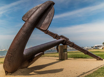 Close-up of rusty metal on beach against sky