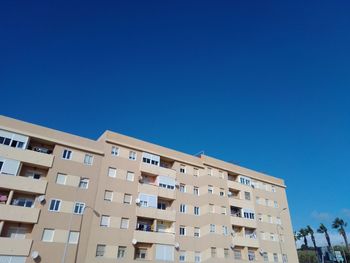 Low angle view of buildings against clear blue sky