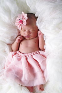 High angle view of cute topless baby girl sleeping on bed at home