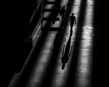 High angle view of silhouette people on footpath in city