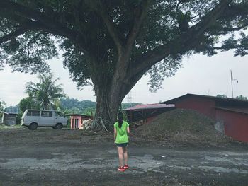 Full length of woman standing on tree trunk
