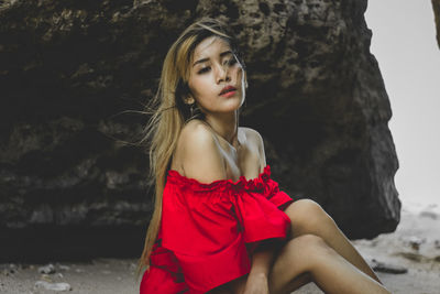 Portrait of a beautiful young woman sitting at the beach