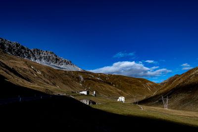 Scenic view of snowcapped mountains against blue sky