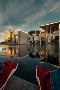 Reflection of buildings in lake against sky