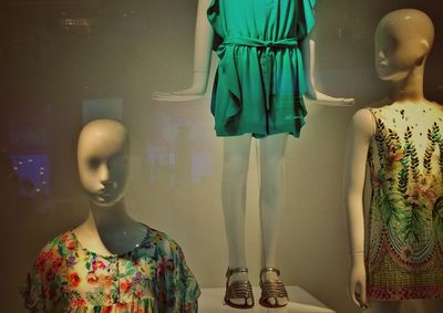 Mannequins seen through store window in shopping mall