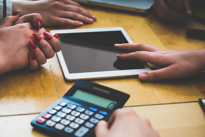 Midsection of man using smart phone on table