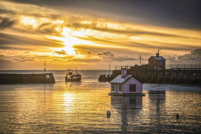 Folkestone harbour at sunrise. a fishing boat enters the harbour. 