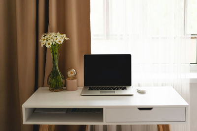 Workplace with laptop and home decor on the table