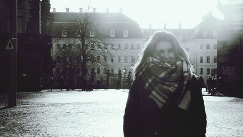 Woman standing on snow covered city in winter