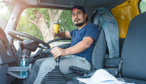 Young man sitting on seat in bus