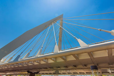 Low angle view of suspension bridge against clear blue sky