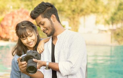 Young couple photographing swimming pool