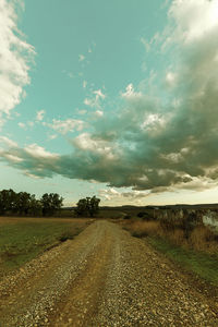 View of dirt road along countryside landscape