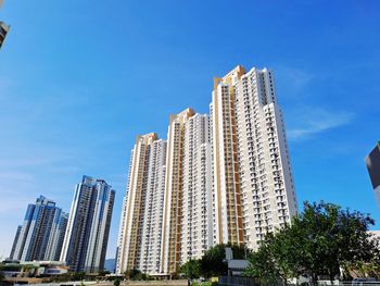 Low angle view of modern buildings against clear blue sky