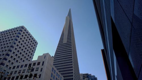 Low angle view of skyscrapers against blue sky