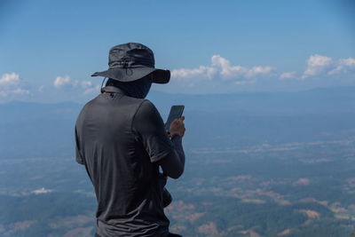 Rear view of man photographing at camera