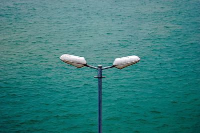 Close-up of telephone pole by sea