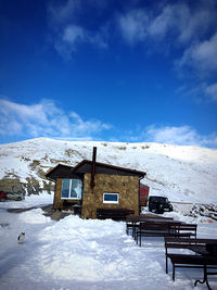 Houses on snow covered landscape against sky