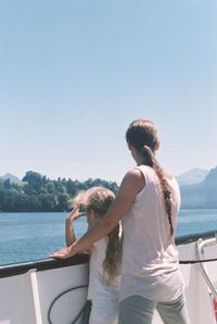 Rear view of couple on sea against clear sky