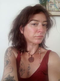 Close-up portrait of young woman against wall