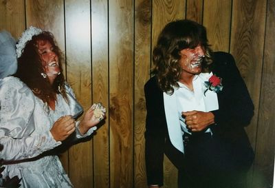 Happy couple playing with cake during wedding ceremony