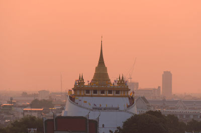 Buildings in city against sky during sunset