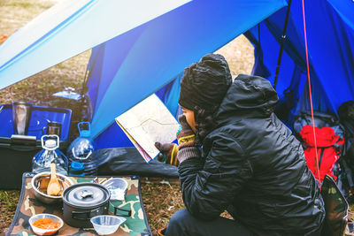 Man sitting on chair at campsite