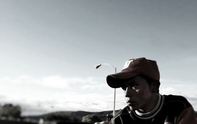 Close-up of man with arms raised against sky