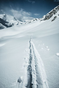 Snow covered landscape against sky