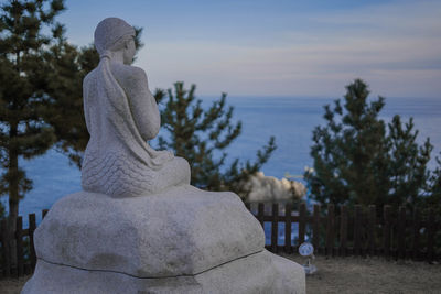 Statue against sky at cemetery