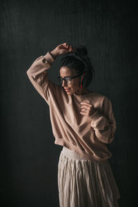 Woman listening music against wall