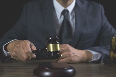 Midsection of man holding coffee cup on table
