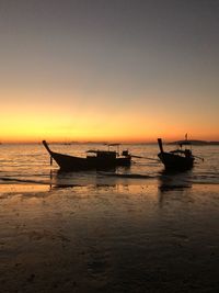 Silhouette boat in sea against sky during sunset