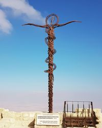 Low angle view of cross on building against sky