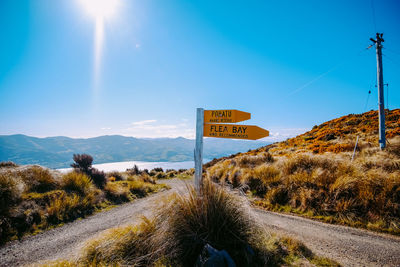 Road signs on landscape against sky