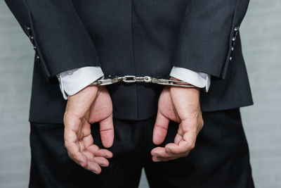 Midsection rear view of businessman with handcuffs