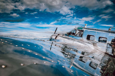 Low angle view of abandoned ship in sea against sky