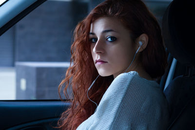 Portrait of beautiful young woman sitting in car