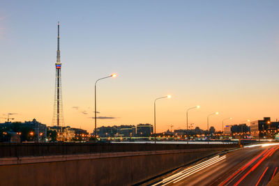 Light trails on road against sky during sunset