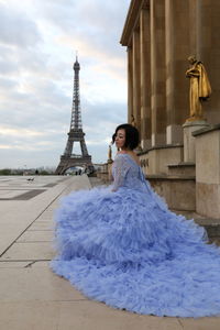 Woman wearing blue dress against eiffel tower