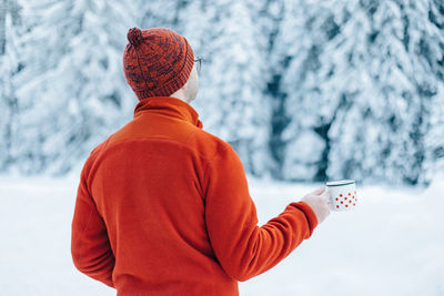 Rear view of man standing on snow