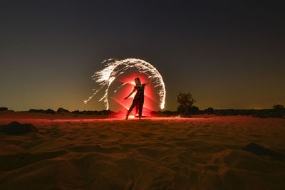 Woman standing at beach against sky at night