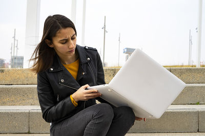 Female student looking at her broken computer.