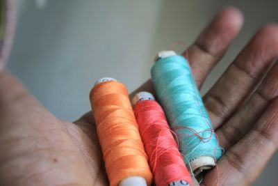 Close-up of hand holding thread spool